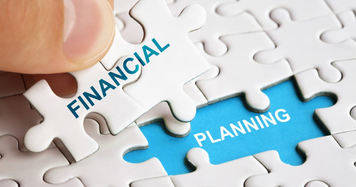 Hand holding piece of puzzle with words Financial Planning.